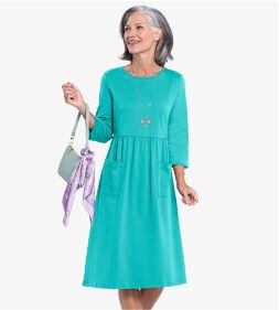 woman wearing green dress holding a purse