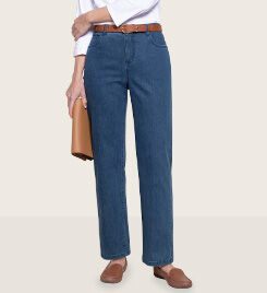 lower half of person walking and wearing dark blue jeans