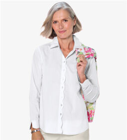 woman wearing white button-up shirt holding a floral jacket on her shoulder