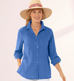 smiling model wearing a blue shirt and tan hat
