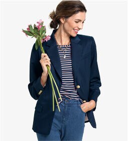 woman wearing navy blazer over blue & white striped shirt, holding bouquet of flowers