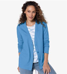 model smiling while wearing a blue cardigan and pants