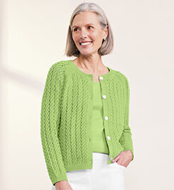 model wearing green sweater and white pants