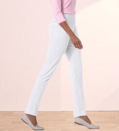 lower portion of model wearing white pants and shoes with a pink shirt