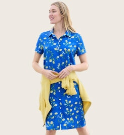 model smiling wearing a light blue floral dress and yellow sweaters around the waist