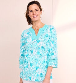 smiling model wearing a blue and white floral shirt