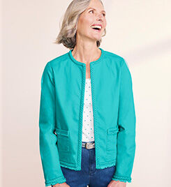 model wearing teal jacket and white dot shirt over blue jeans