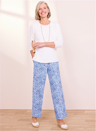 model wearing white top and patterned blue pants with white shoes