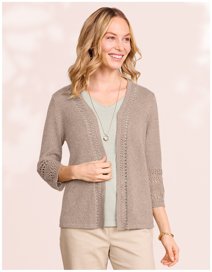 model wearing beige cardigan over foam green shirt and tan pants