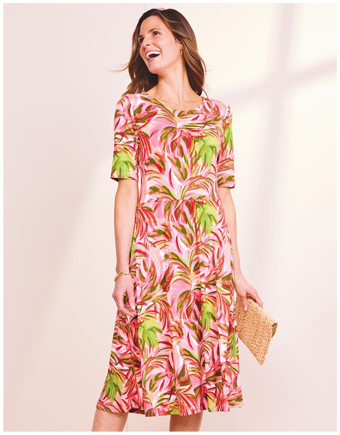 model wearing red, pink, green, and orange patterned dress.