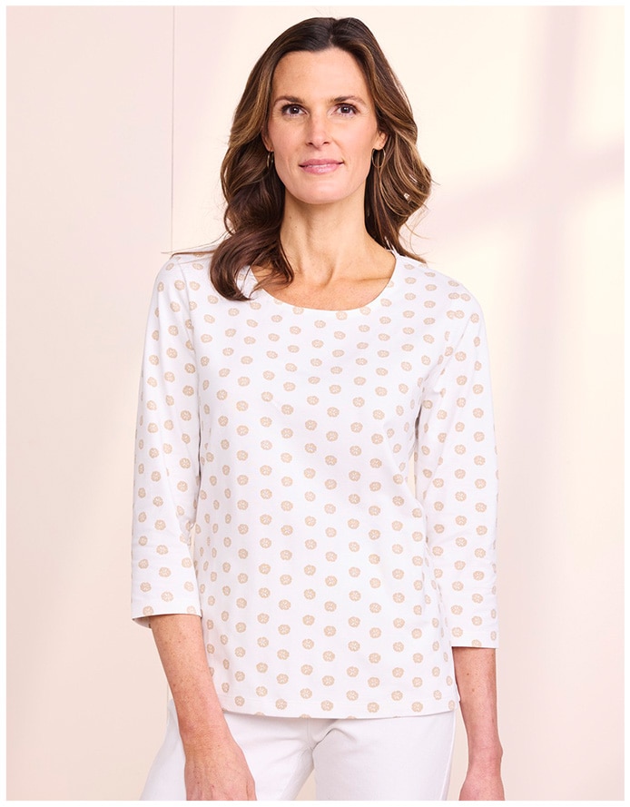 model wearing white top with print and white pants